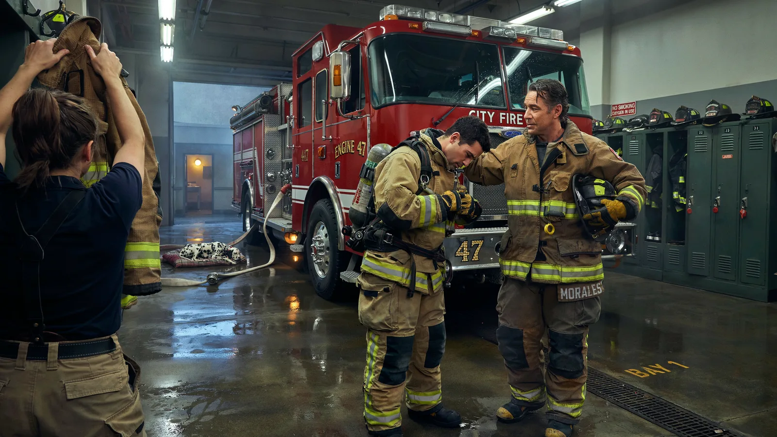 Firefighters suiting up beside a fire engine in the station bay with a dalmatian resting nearby, titled Best Series About Firefighters.