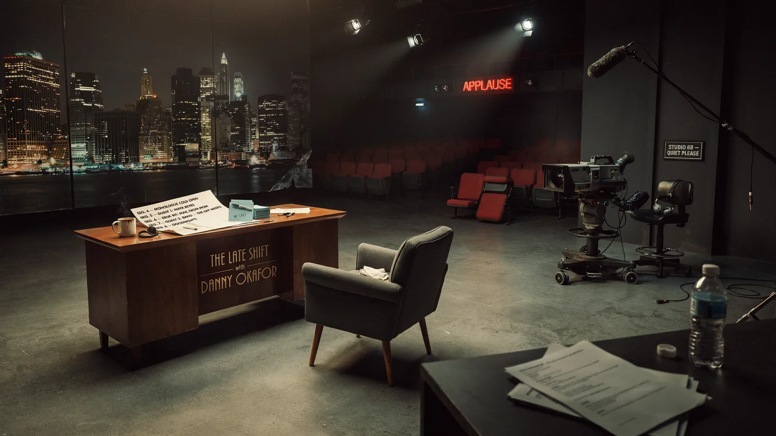An empty late night talk show set with a host's desk, city skyline backdrop, and a lit Applause sign, titled Best Series About Late Night Talk Shows.